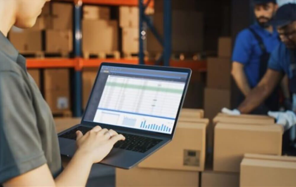 man on laptop in warehouse